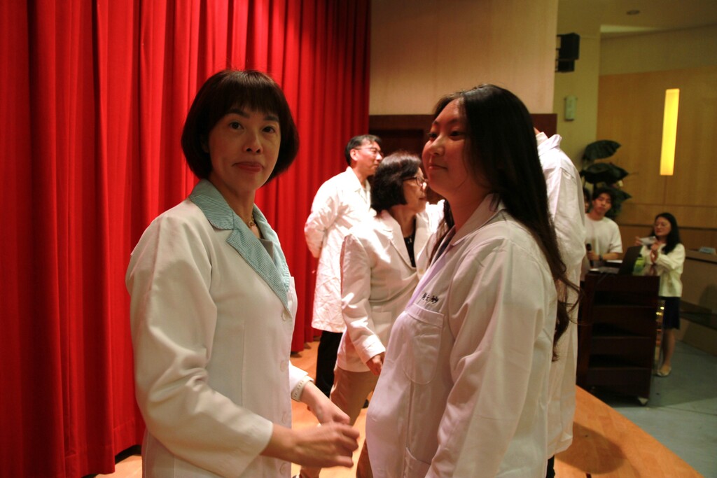 聯新國際醫院病理檢驗科副主任翁麗秋(左)為元培醫技系學生授袍